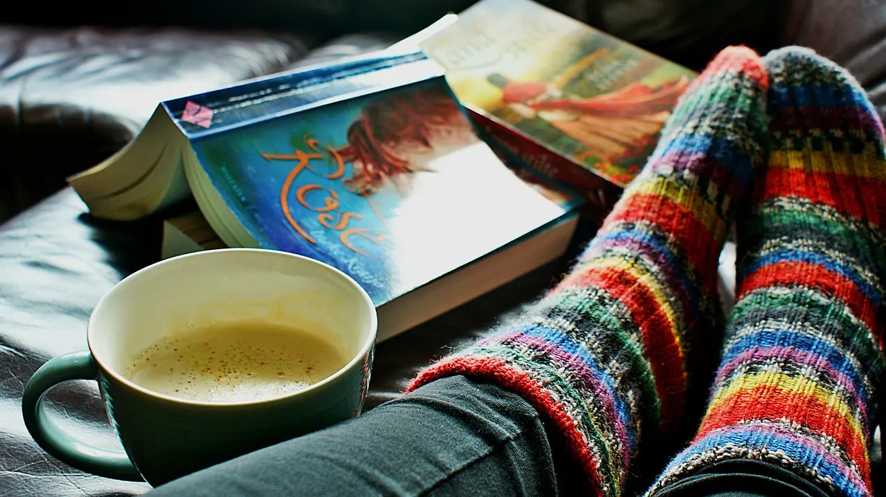 Stock photo: coffee, a good book and striped socks on a cozy evening